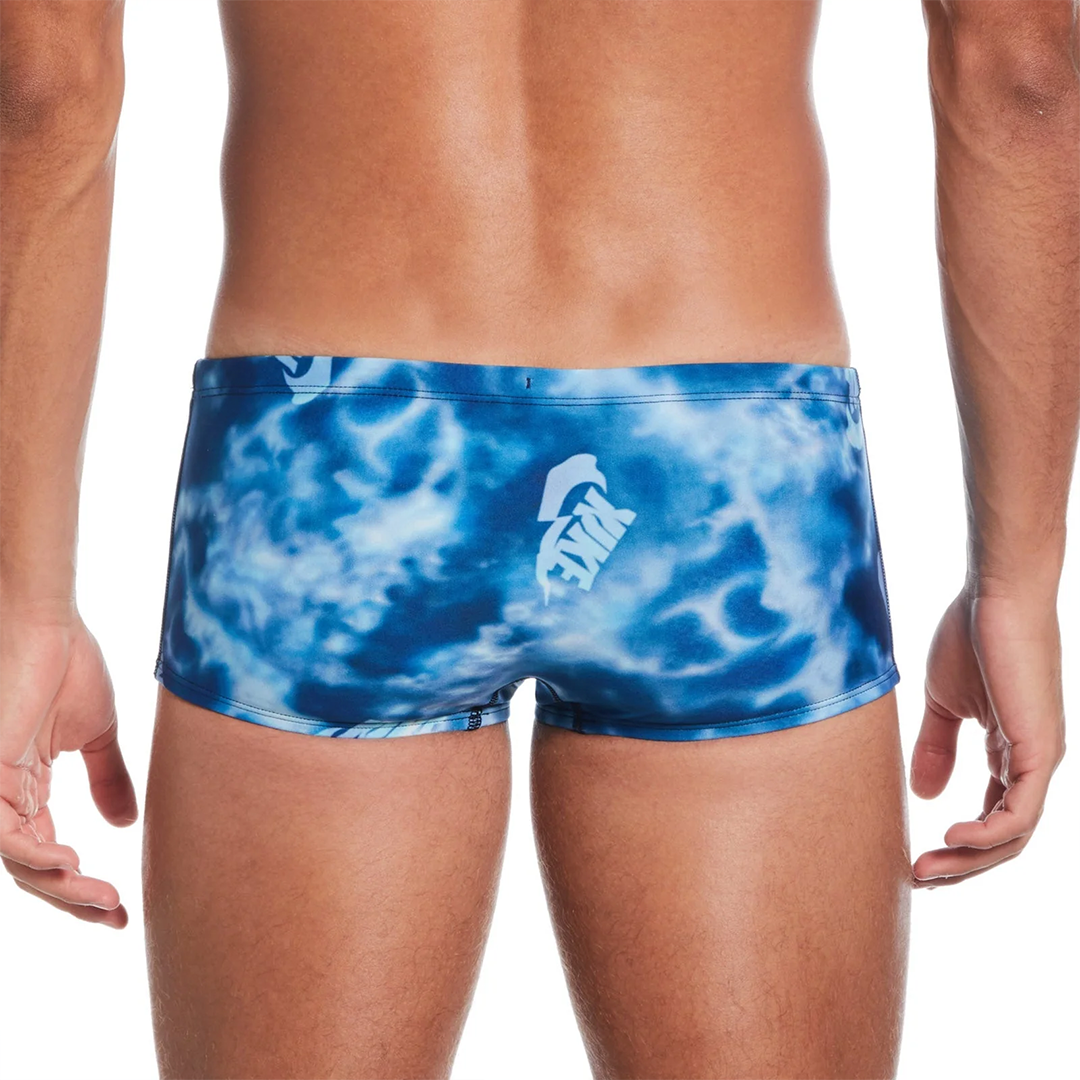 Blue tie-dye swim shorts with a white logo on a white background