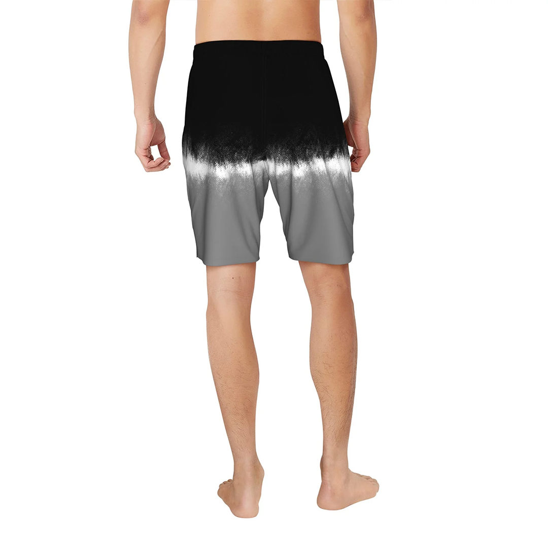Person wearing a black to gray gradient swim shorts on a white background