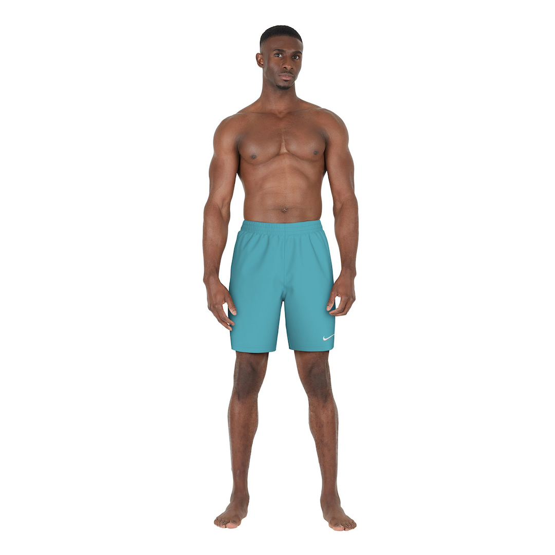 Man wearing teal swim shorts on a white background