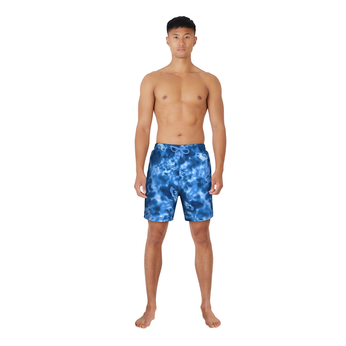 Man wearing blue tie-dye swim shorts on a white background